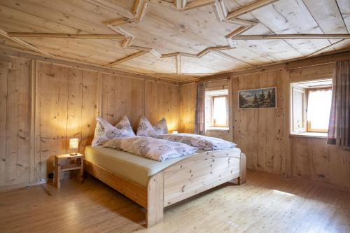阿尔代兹Chasa Broel Ferienhaus mitten in Ardez的一间卧室设有一张木天花板床。