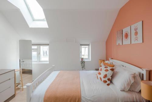 伦敦Wonderland - Fitzrovia - by Frankie Says的卧室配有白色的床和橙色的墙壁。