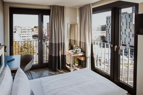 柏林Emma by Schulz Hotel Berlin Friedrichshain的酒店客房设有一张床和大窗户