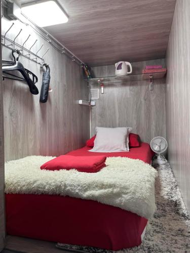 基希讷乌Single in the room hostel的一间卧室配有一张带红白毯子的床
