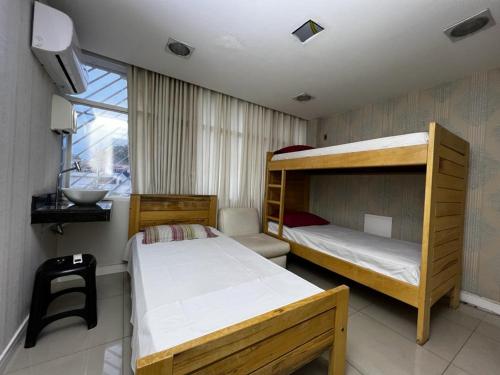 巴西利亚Hospedagem BRASILIANAS的一间卧室设有两张双层床和一扇窗户。