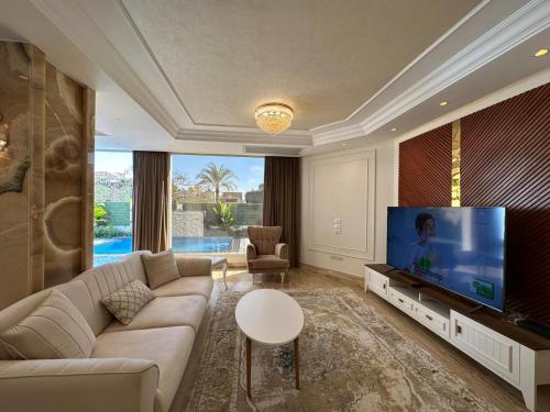 Sheikh ZayedAl Sawah Stand Alone Villa With Private Pool的带沙发和平面电视的客厅