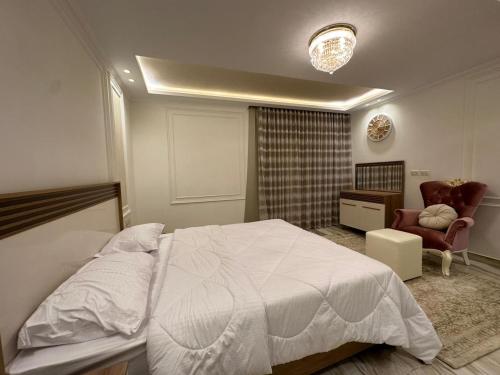 Sheikh ZayedAl Sawah Stand Alone Villa With Private Pool的卧室配有白色的床和椅子