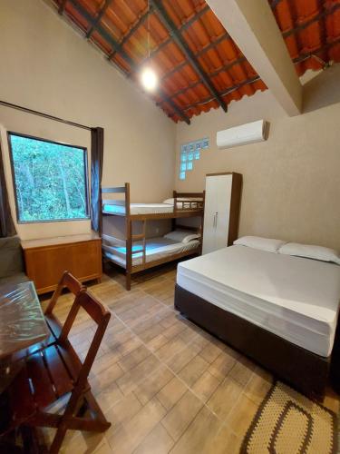 卡瓦坎特Recanto Gira Cerrado的一间卧室配有一张床、一张书桌和一个窗户。