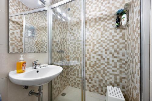 拉戈斯Mdc - Muralhas da Cidade的一间带水槽和玻璃淋浴的浴室