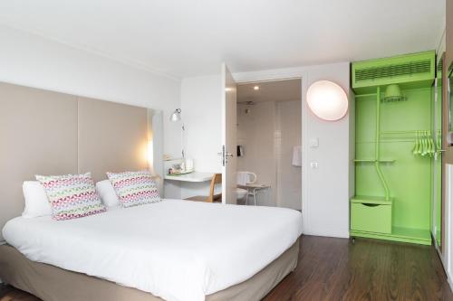 马恩河畔博纳伊克莱特伊康铂酒店 - 博纳伊苏尔马恩的卧室配有白色的床和绿色的墙壁
