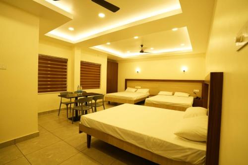 古鲁瓦尤尔SREENARAYANA TOURIST HOME的酒店客房设有两张床和一张桌子。