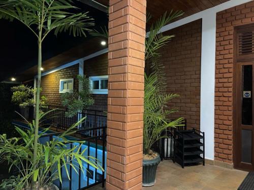 康提藤索拉宾馆的建筑前方有植物的砖柱
