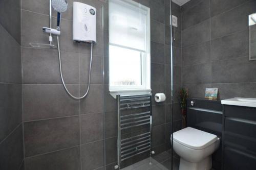 特伦Ideally Located Modern Flat的带淋浴、卫生间和窗户的浴室