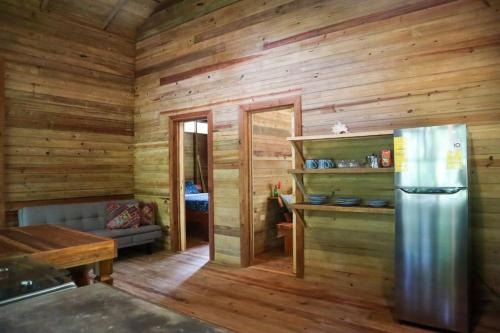 博卡斯德尔托罗Jungle beach 2 bedroom cottage的一间带木制墙壁和冰箱的厨房