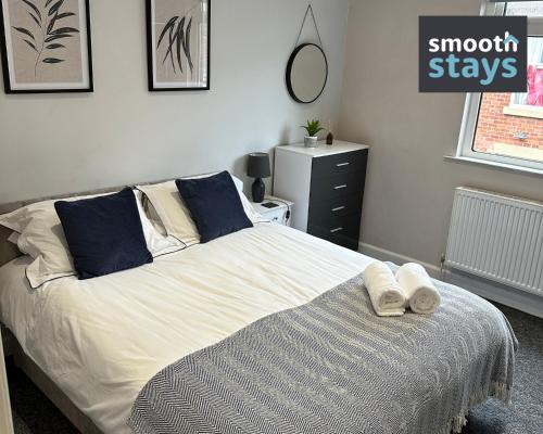 普雷斯顿Modern 2 Bed Apartment By Smooth Stays Short Lets & Serviced Accommodation Preston With Parking Near Train Station的一间卧室配有一张床,上面有两条毛巾