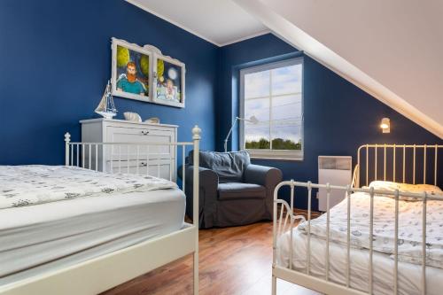 卡尔维亚Dom Kotwa的卧室拥有蓝色的墙壁,配有一张床和椅子