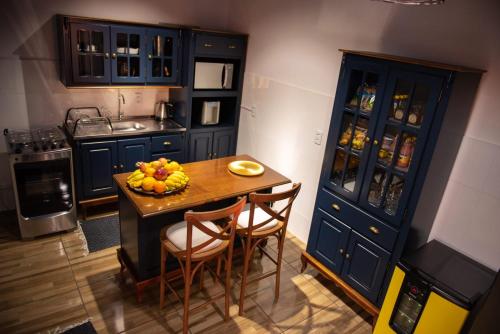 Volta GrandePousada Nonno Fiorindo的厨房配有蓝色橱柜和水果桌