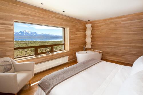 百内三塔Tierra Patagonia的一间卧室设有一张床和一个大窗户