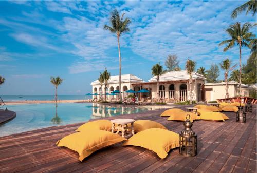 蔻立Devasom Khao Lak Beach Resort & Villas的海滨度假胜地,设有一座带黄伞的游泳池