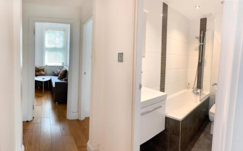 伦敦Central Location 2 bed flat, Zone II, London NW6的白色的浴室设有水槽和浴缸。