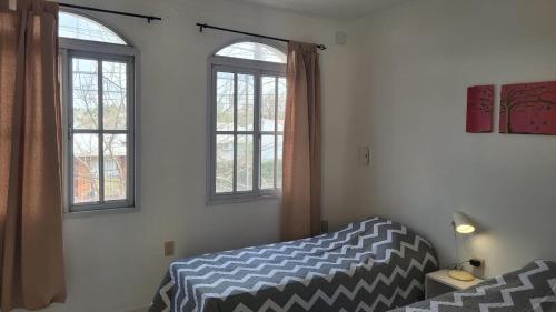 巴拉那La Casona的一间卧室设有一张床和两个窗户。