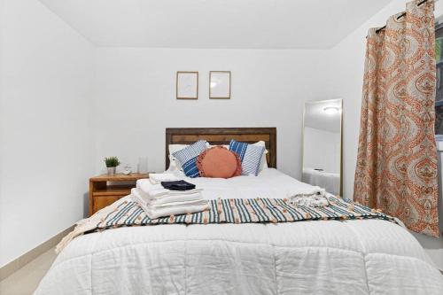达尼亚滩Beach Blessing 7m Beach Walk 80 WD 2 Queen的卧室配有带蓝色枕头的大型白色床