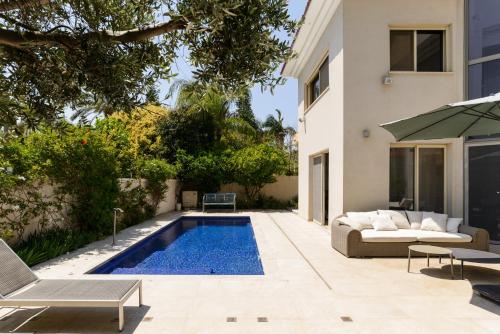 荷兹利亚Maison d architecte的一个带游泳池和房子的后院