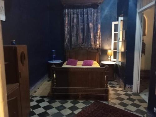 拉腊什La Maison Haute Larache Morocco的一间卧室配有一张带紫色枕头的床