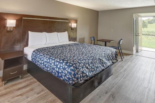 赛维尔维尔Econo Lodge Sevierville-Pigeon Forge on the River的酒店客房设有床、桌子和窗户。