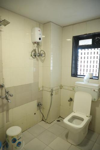 孟买Hotel Shiv Leela Grand的白色的浴室设有卫生间和窗户。