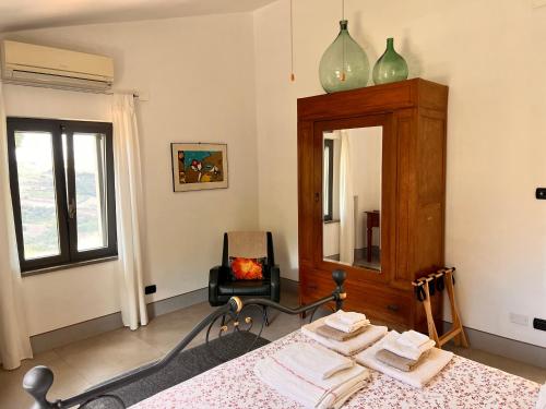塞尔苏里格La Fontanella Country House的一间卧室配有一张床、镜子和椅子