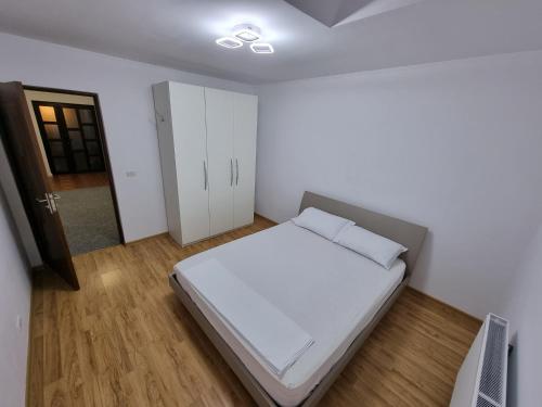 Letea VecheCasa Sava的卧室配有白色的床和衣柜。