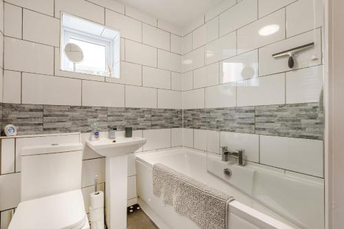 埃克斯茅斯Keeling的白色的浴室设有浴缸和水槽。