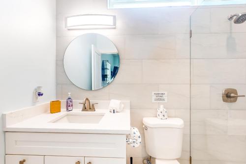 圣奥古斯丁The Blue Heron Cottage的白色的浴室设有水槽和镜子