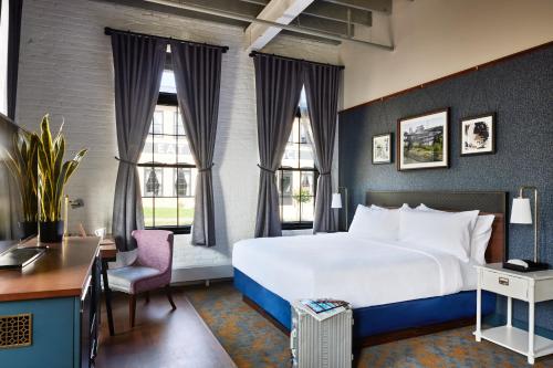HastingsThe Confluence Hotel的酒店客房设有一张大床和窗户。