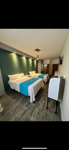 La BarcaHotel Real Briseñas的酒店客房配有两张床和一张书桌