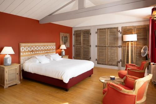 圣马丹德雷La Martinoise Garden的一间卧室配有一张大床和两把椅子