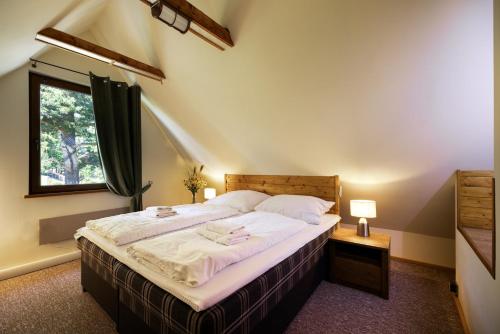 斯塔拉·里斯拉Chalet Green Park的一间卧室配有一张带白色床单的床和一扇窗户。