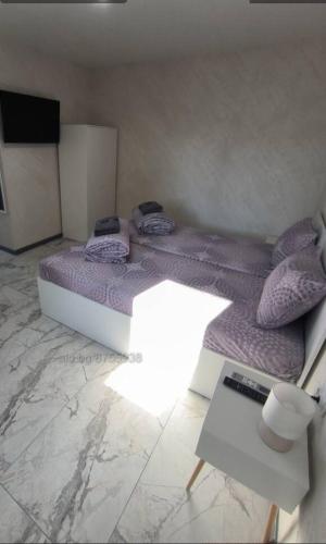 斯利文Студио Ава 2的一间卧室配有一张大床,提供紫色床单和枕头