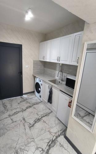 斯利文Студио Ава 2的厨房配有白色橱柜、洗衣机和水槽