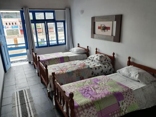 卡波布里奥Pousada do Goiano的一间卧室设有三张床和窗户。