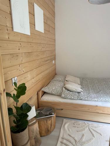 WólkaStrefa medytacji的小房间,木墙里设有一张床