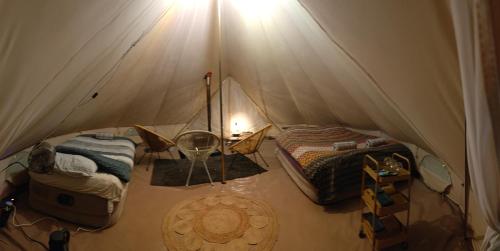 LabroyeAu Pied Du Trieu, the glamping experience的帐篷配有两张床和一张桌子