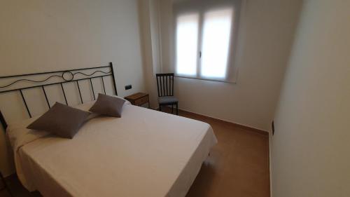 特鲁埃尔La Yecla Teruel的卧室配有白色的床、窗户和椅子
