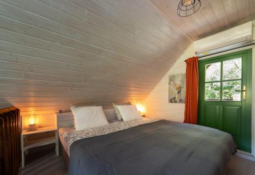 SzokolyaMannana házikó的一间卧室设有一张床和一个绿门