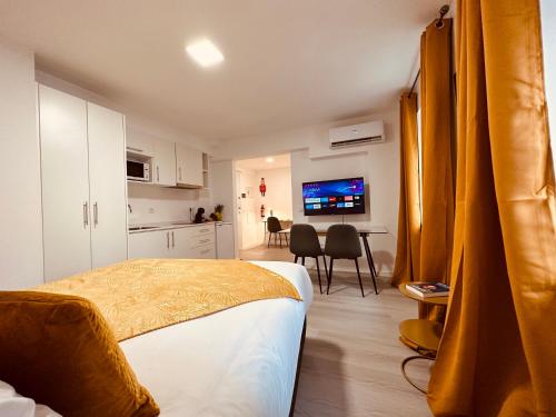 丰沙尔Living Funchal iNN的一间卧室配有一张床,厨房配有桌子