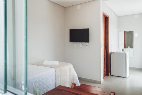 巴拉格兰德Pousada Estrela do Mar的白色的房间,设有床铺和墙上的电视