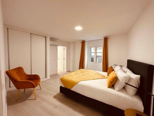 丰沙尔Living Funchal iNN的一间卧室配有一张床和一把椅子