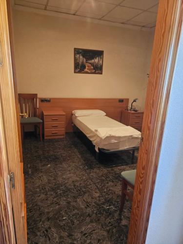 穆尔西亚Hotel restaurante Palacio Fes的一间小卧室,配有一张床和一把椅子