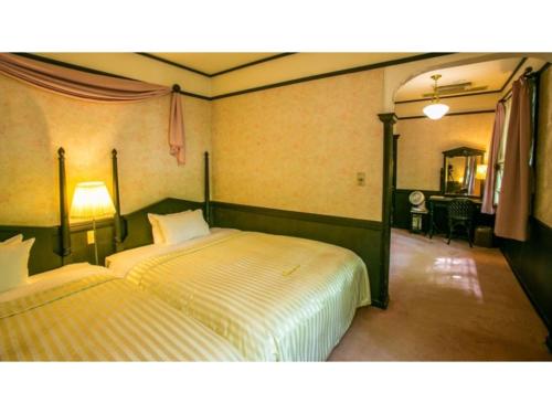 白马村Restaurant & Hotel Traumerei - Vacation STAY 47777v的一间卧室配有两张床和一张书桌。