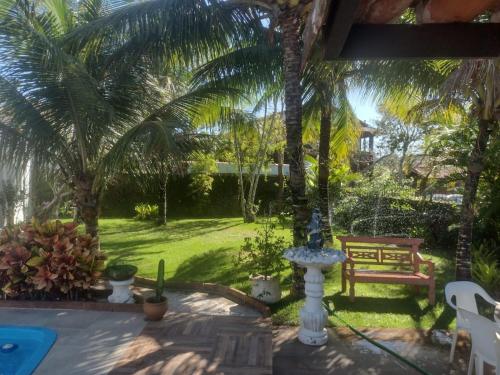 布希奥斯Suite Dupla em Búzios的庭院设有喷泉、长凳和棕榈树
