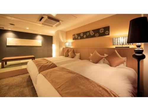 福井Centurion Hotel Villa Suite Fukui Ekimae - Vacation STAY 34650v的一间卧室配有一张大床和一张书桌
