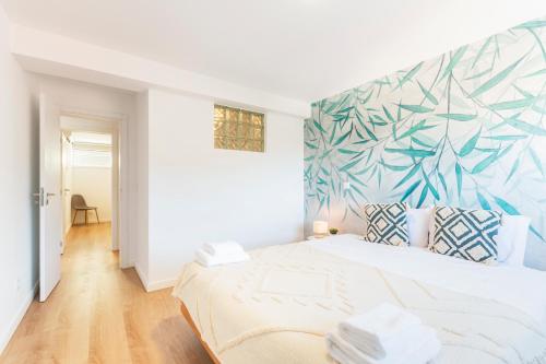 洛里加Loriga View Apartments的一间卧室配有一张带热带壁画的大型白色床。