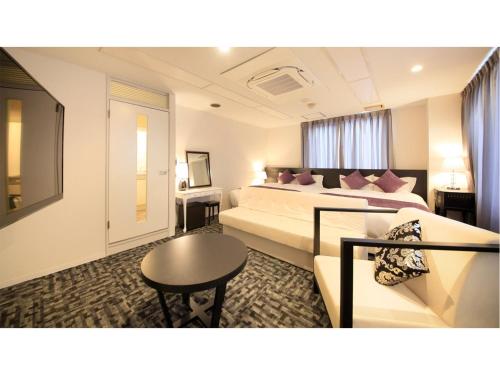 福井Centurion Hotel Villa Suite Fukui Ekimae - Vacation STAY 34640v的酒店客房,设有两张床和一张沙发